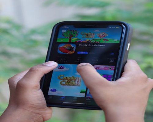 Central smartphone showing the fictional Crown Pixel Foundry creative game